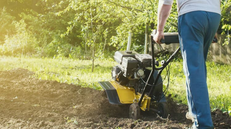 close up view of plowed green land cultivator at work in the garden