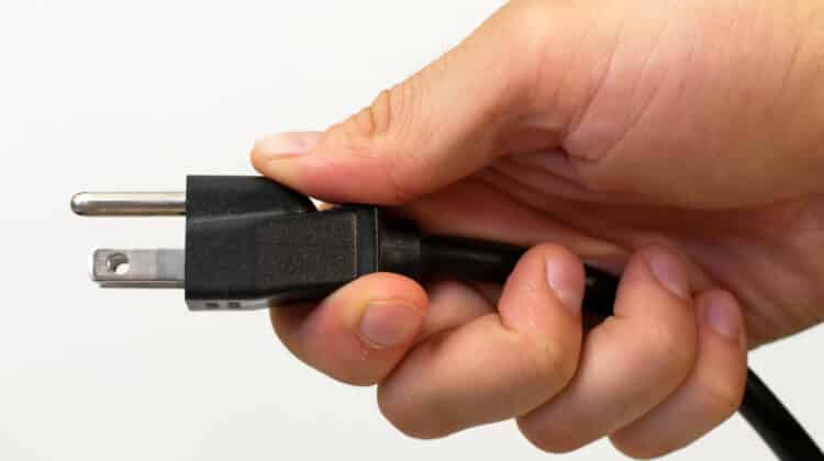 North American electrical cord held in a man's hand