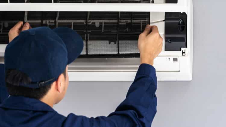 technician service removing air filter of air conditioner