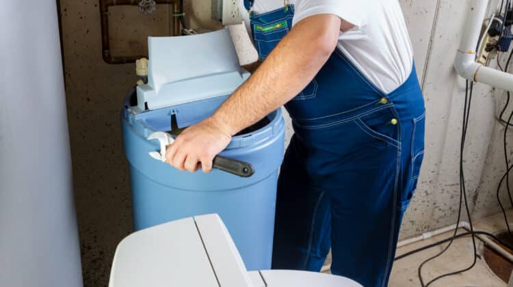 Worker trying to install dungarees Interior worker is cleaning the water softener