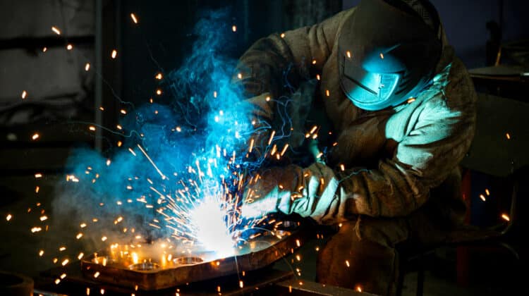 Welder works with a metal product Beautiful sparks in the dark
