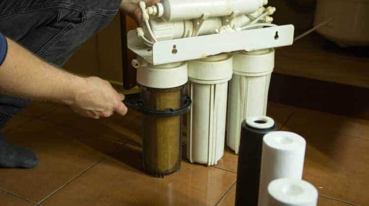 The master replaces dirty filters in the home water purification system