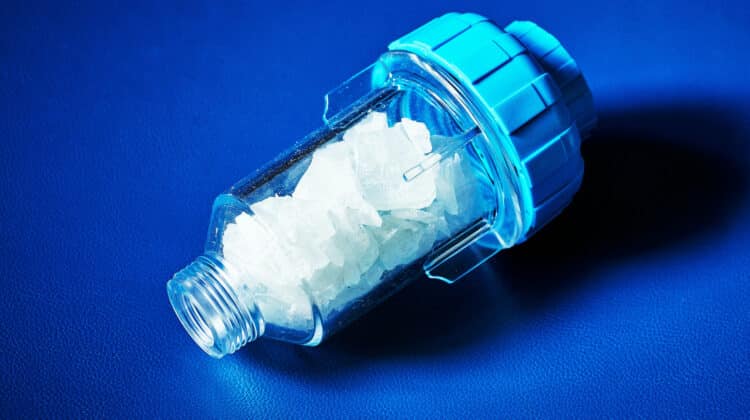 water filter with a crumb of salt crystals on a blue background