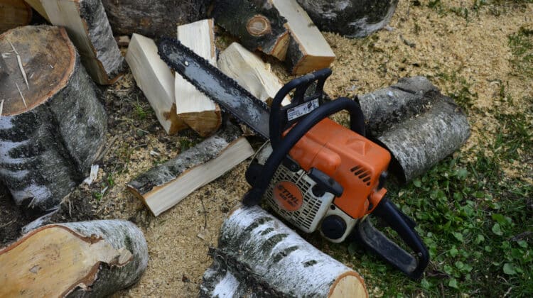 lumberjack chain saw lies on lumber Sawn wood and chainsaw