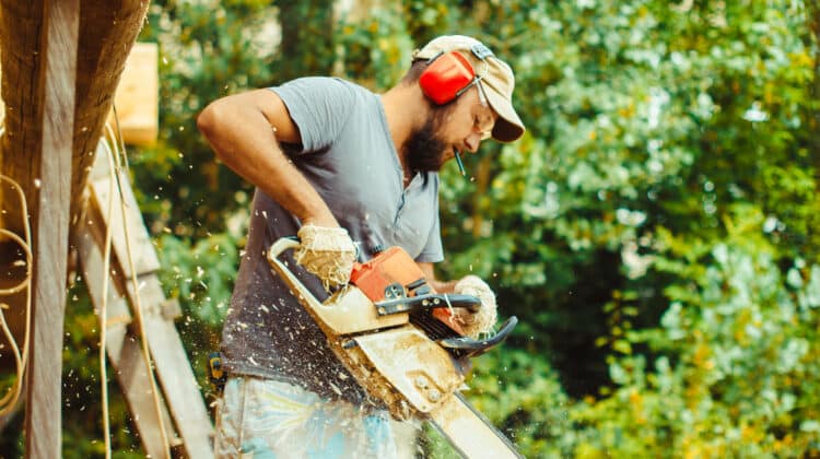 a man is sawing a log with a saw