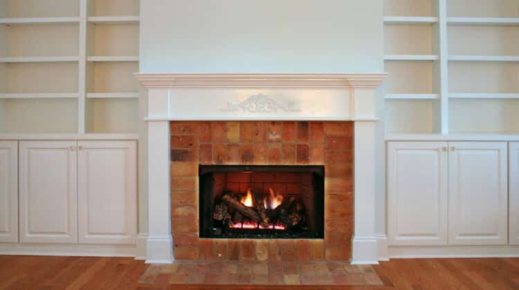 lit fireplace surrounded by reclaimed brick