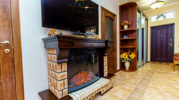 Electric fireplace between the doors Over the fireplace TV