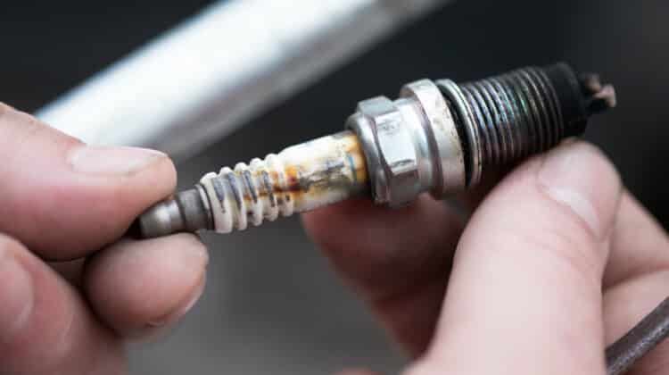 A worn spark plug in male hand