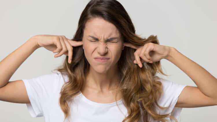 Stubborn woman sticking fingers in ears not listening to noise