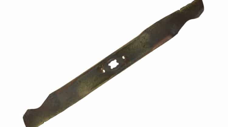 Top view of a lawn mower blade that is gouged and worn on a white background