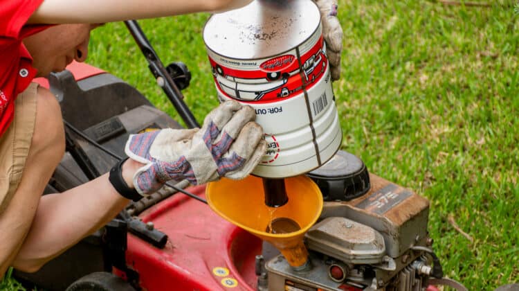 Refueling of an old lawn mower with petrol gasoline