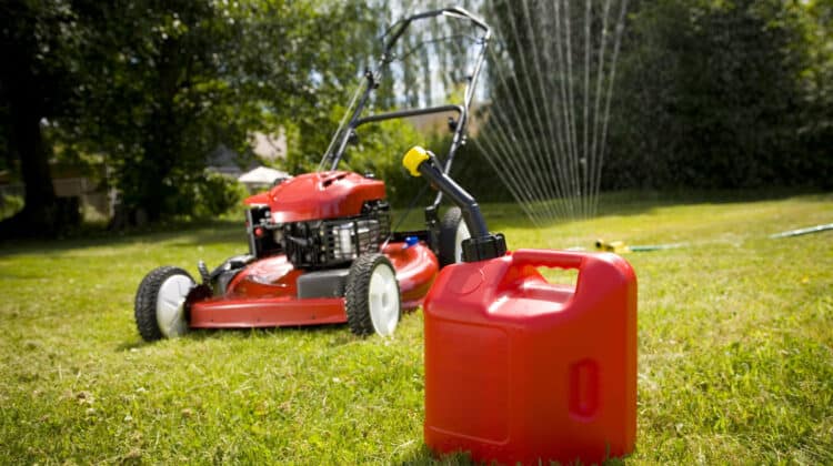 A red lawn mower and gas can in fresh cut grass