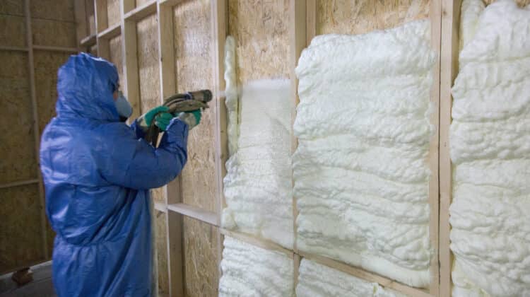 Craftsman worker spray foam inside wall
