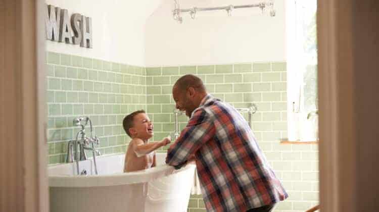Father And Son Having Fun At Bath Time Together