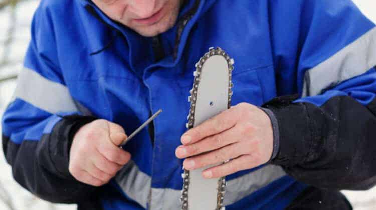man repairing chainsaw