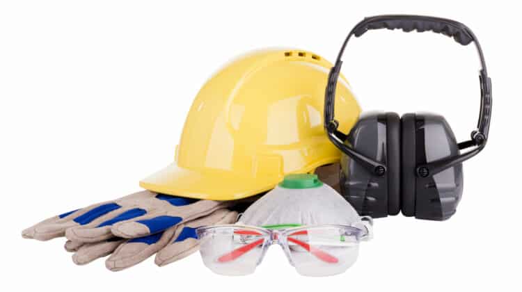 Safety equipment or PPE personal protective equipment with hard hat safety glasses gloves face mask and earmuffs isolated on white