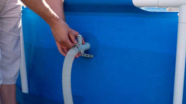 A man checks a filter for cleaning a home pool