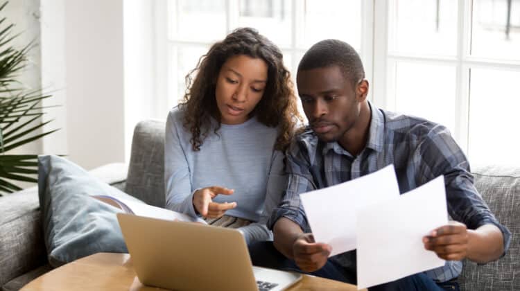 couple reading document or bank contract looking at paper documents for roofing insurance