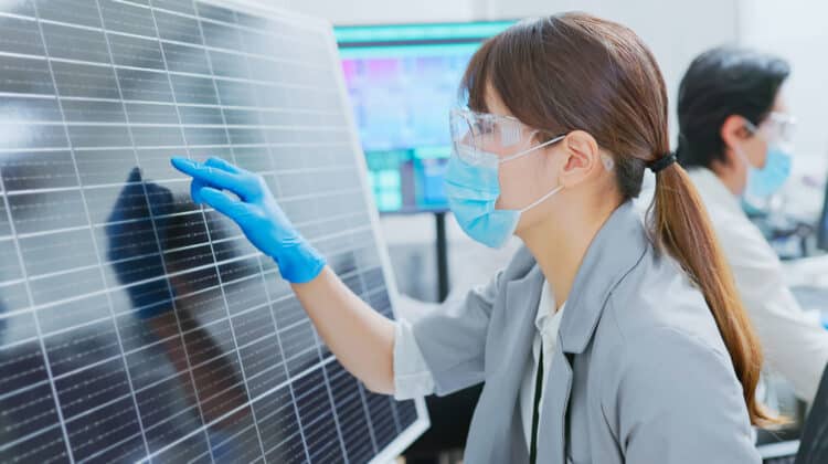 asian engineer team are working with computer and a woman examining solar panel in office