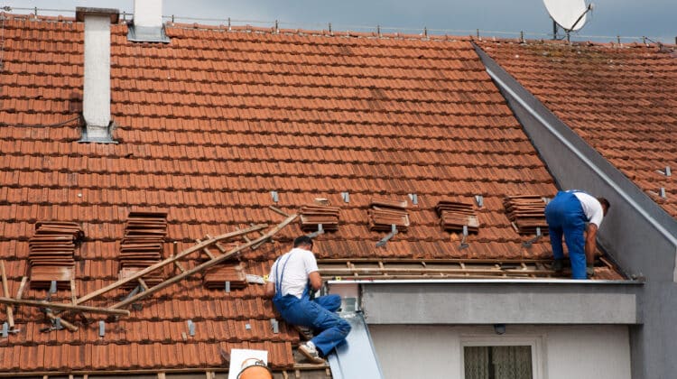Two men working on the roof repairing roof
