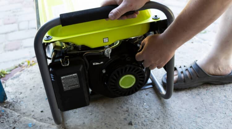 Man pulls cord from mobile gas generator Concept of vehicle starter Start-up gas machine