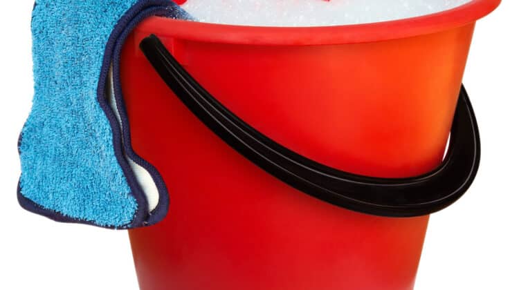 Red plastic bucket and floor cloth with salt for melting ice