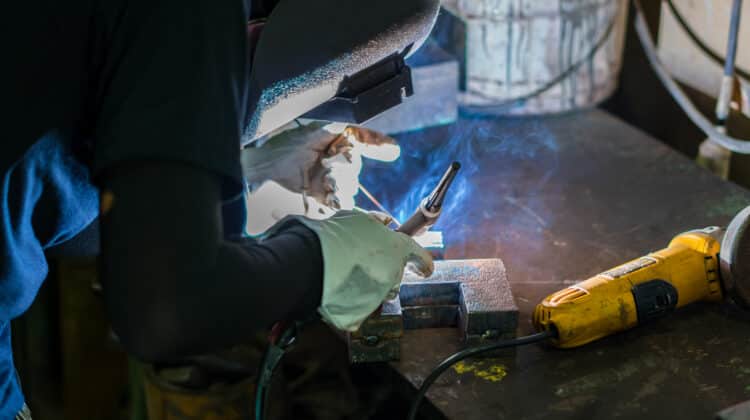 Welder welding arc steel pipe in industrial factory Welder welding with stainless steel arc welding