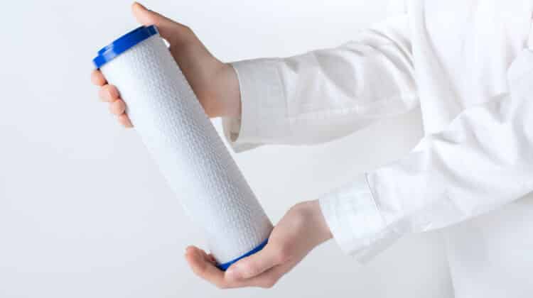 water filter cartridge in human hand isolated on white