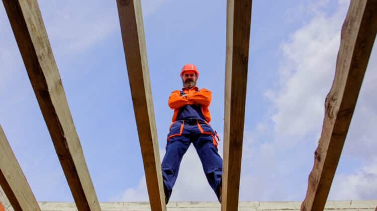 Roofer carpenter builder working on roof structure on construction site