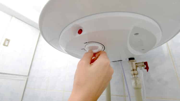 A woman switches the boiler to a higher or lower temperature