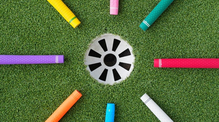 Colorful golf grips point to the hole with ball